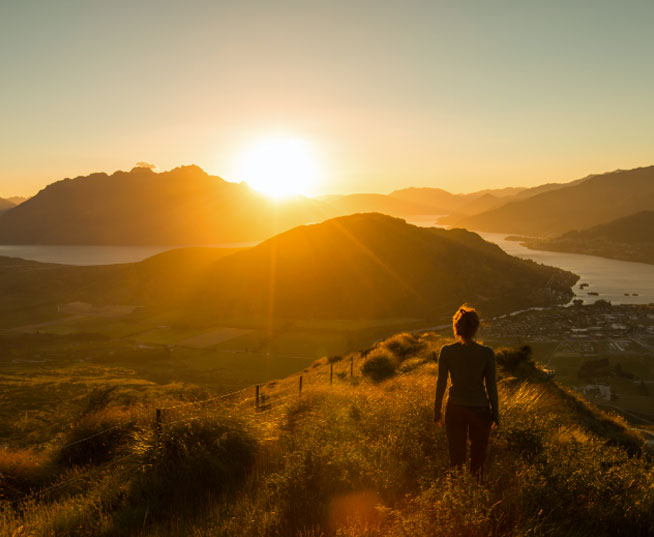 A person hiking overlooking a sunset